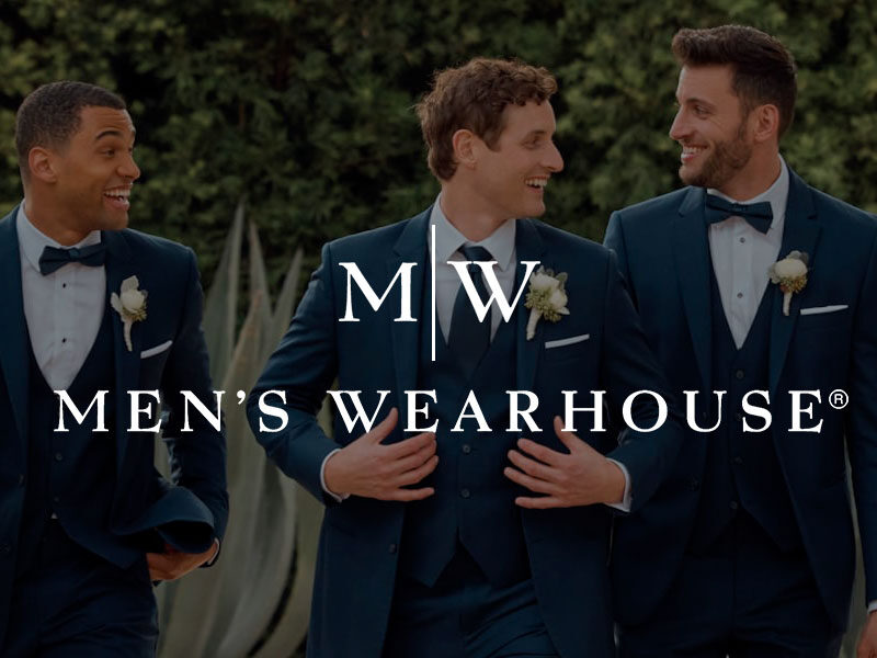 Men's Wearhouse logo over an image of A groom and three groomsmen dressed in navy blue suits walking outdoors.