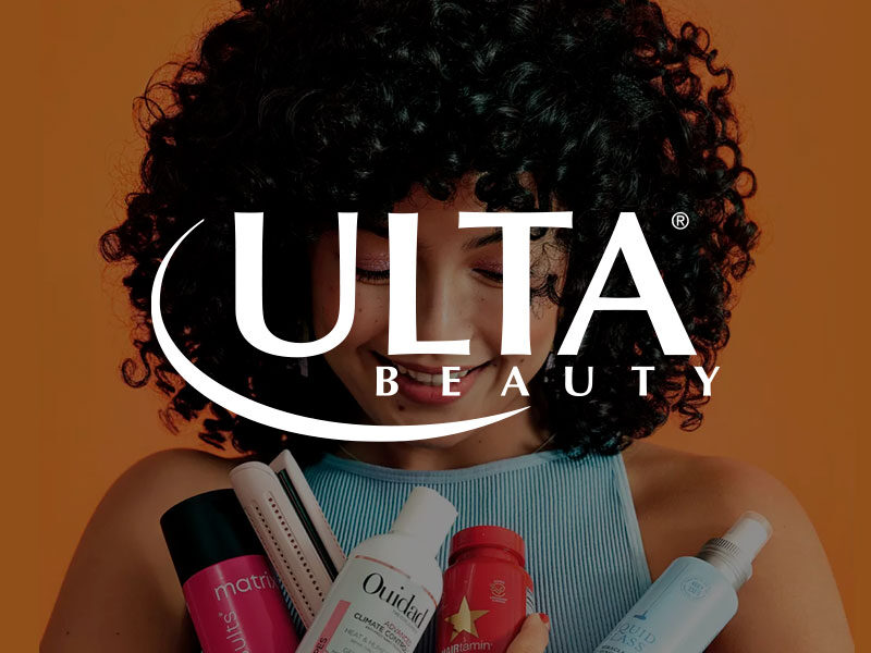 Ulta Beauty logo over an image of an Attractive woman with thick, black curly hair holding various hair care products.
